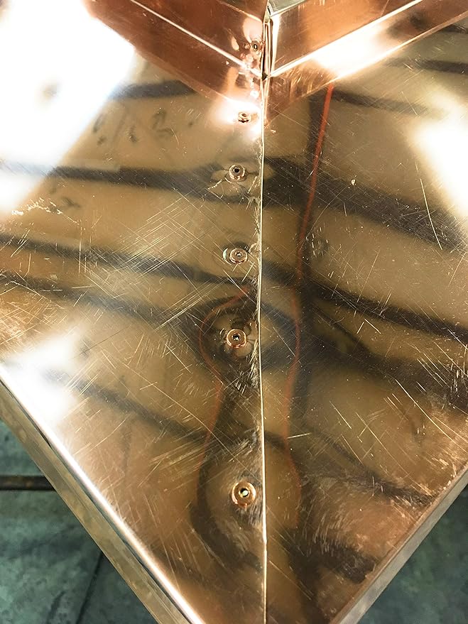 Several Copper Pop Rivets that have been inserted into copper flashing.