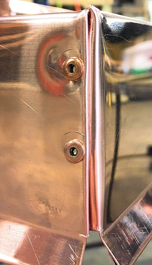 Two Copper Pop Rivets that have been inserted into copper flashing.