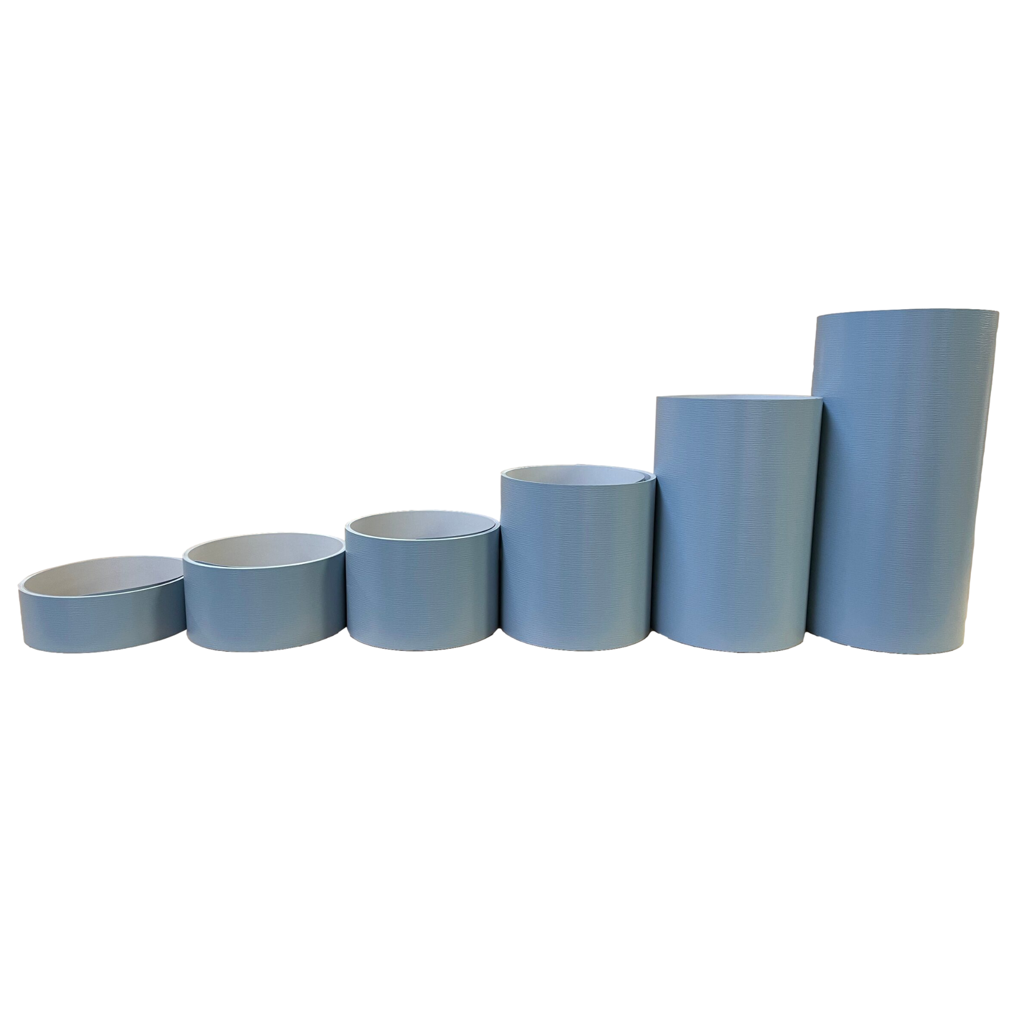Various rolls of Woodgrain Finish Aluminum Trim Coil positioned next to each other to visualize each size offered. Each roll is Polaris Blue in color.