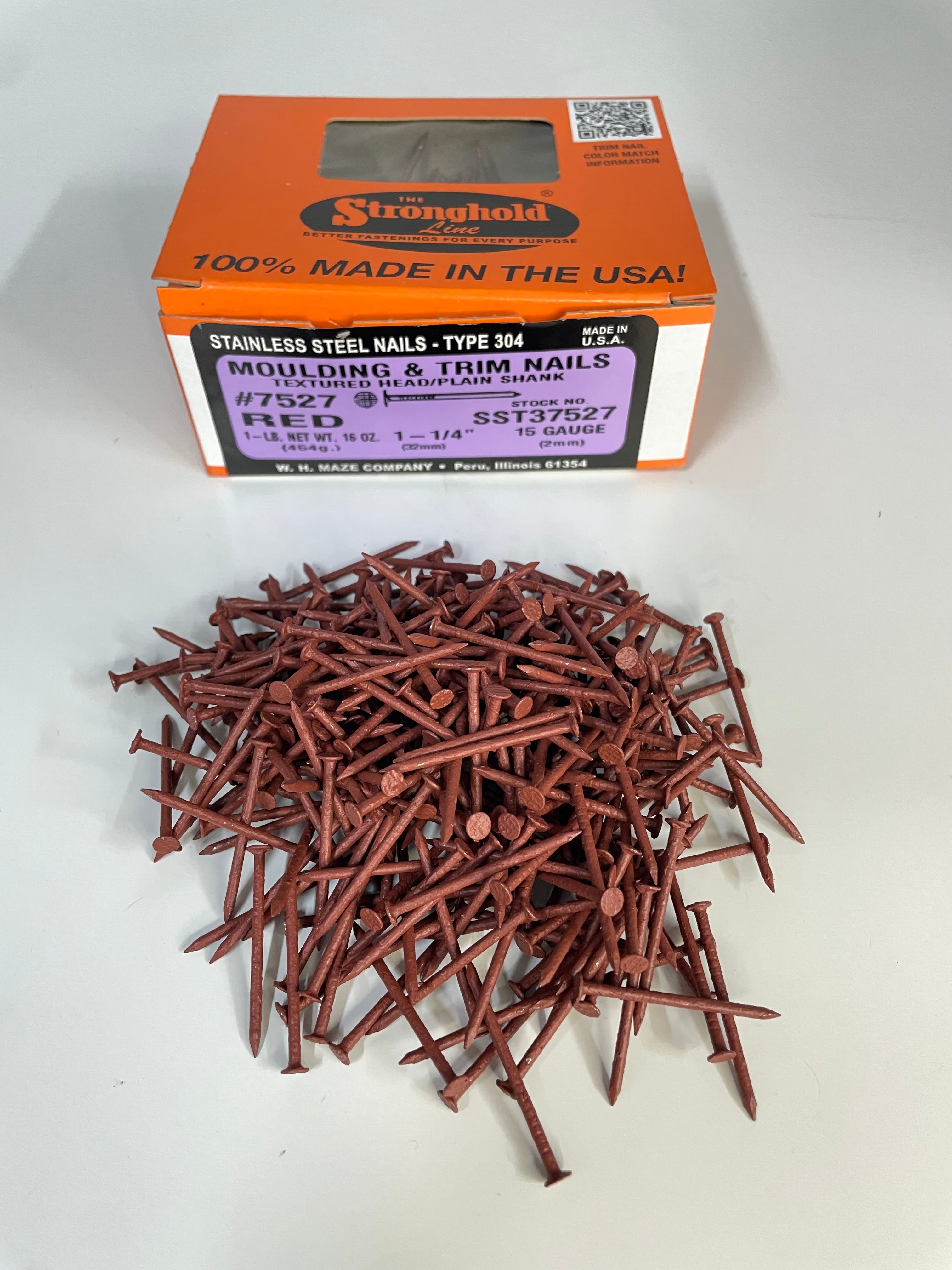 A box of Stainless Steel Trim Nails with a pile of loose nails in front of it. The nails are Rosewood in color.