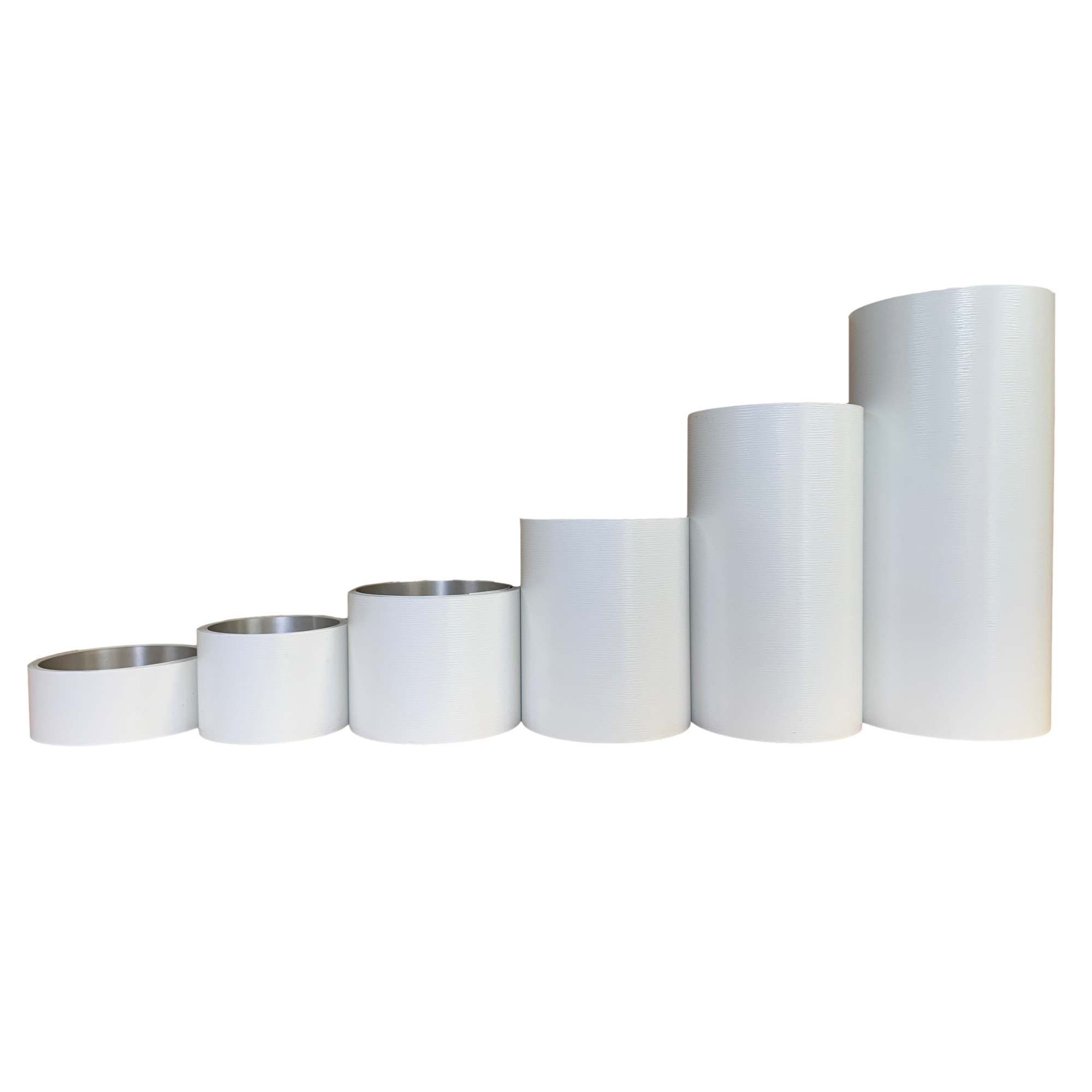 Various rolls of Woodgrain Finish Aluminum Trim Coil positioned next to each other to visualize each size offered. Each roll is White in color.