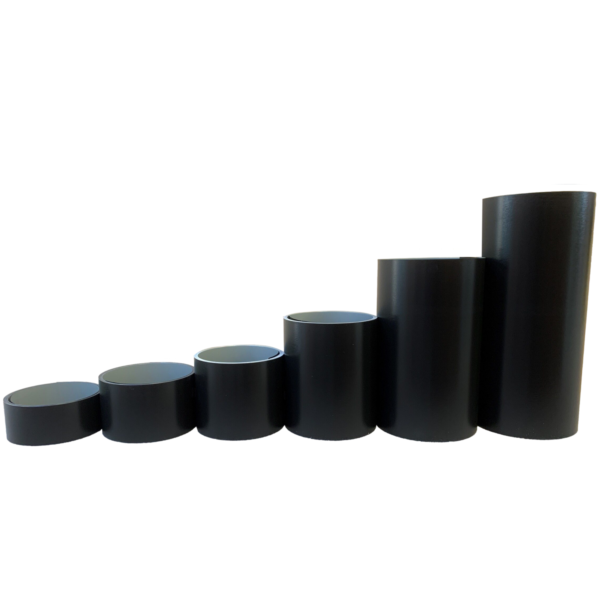 Various rolls of Woodgrain Finish Aluminum Trim Coil positioned next to each other to visualize each size offered. Each roll is Black in color. 